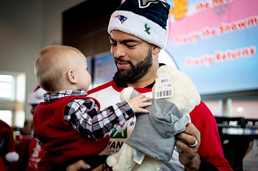 Kyle Van Noy giving a gift to a child